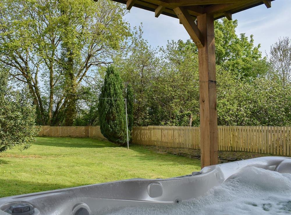 Look out over the garden from the relaxing hot tub at Maes Yr Onnen in Abercych, near Cardigan, Dyfed