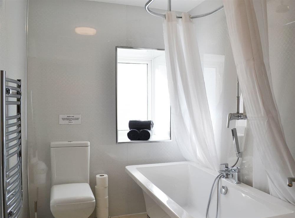 Stylish en-suite bathroom to the master suite with roll top bath and overhead shower at Kingfisher, 