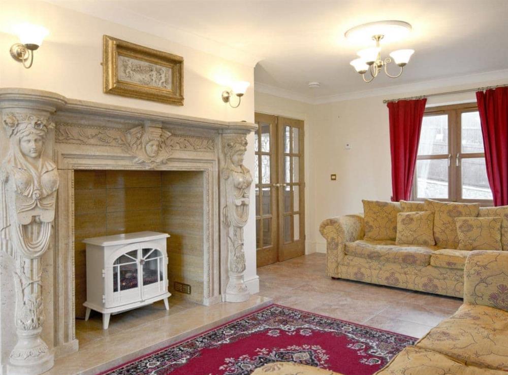 Stylilsh living room with french doors and tiled floor at Magnolia Cottage in Aberaeron, Dyfed