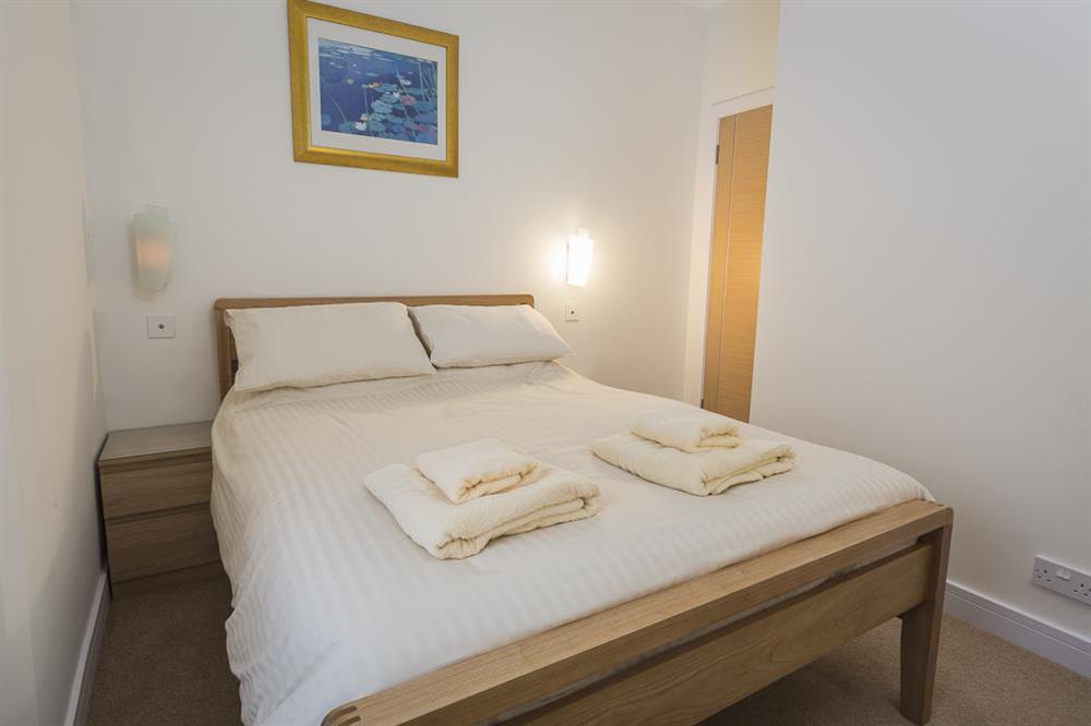 Double bedroom featuring new wooden-framed bed at Main Top Apartment in , Salcombe