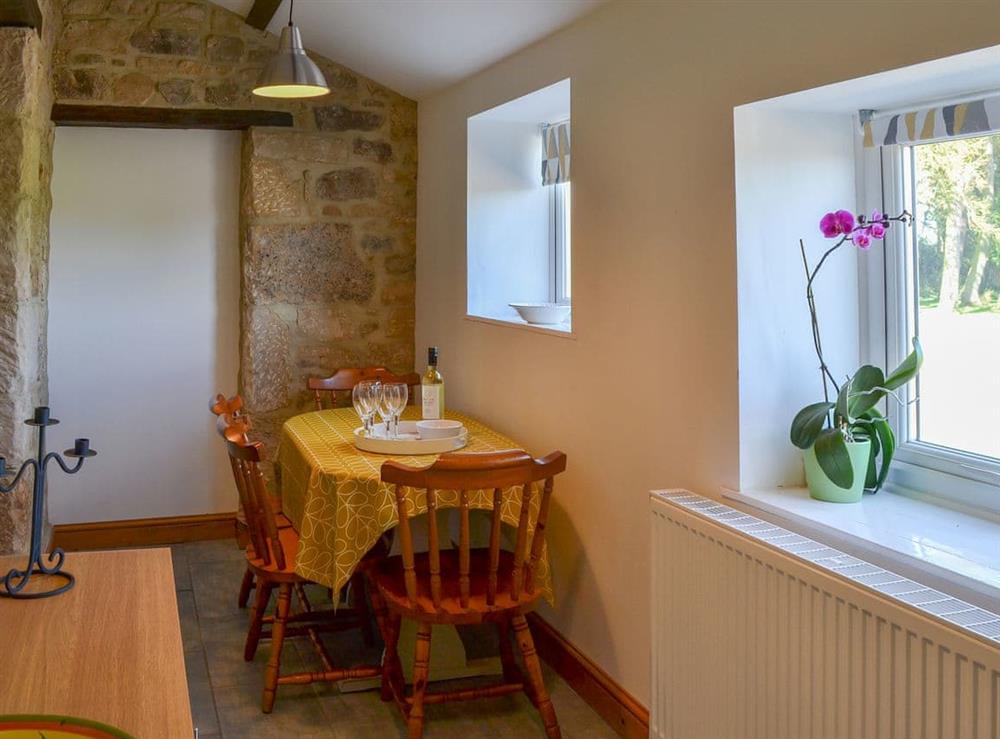 Dining area with exposed stone walls at Mains Cottage in Belford, near Bamburgh, Northumberland