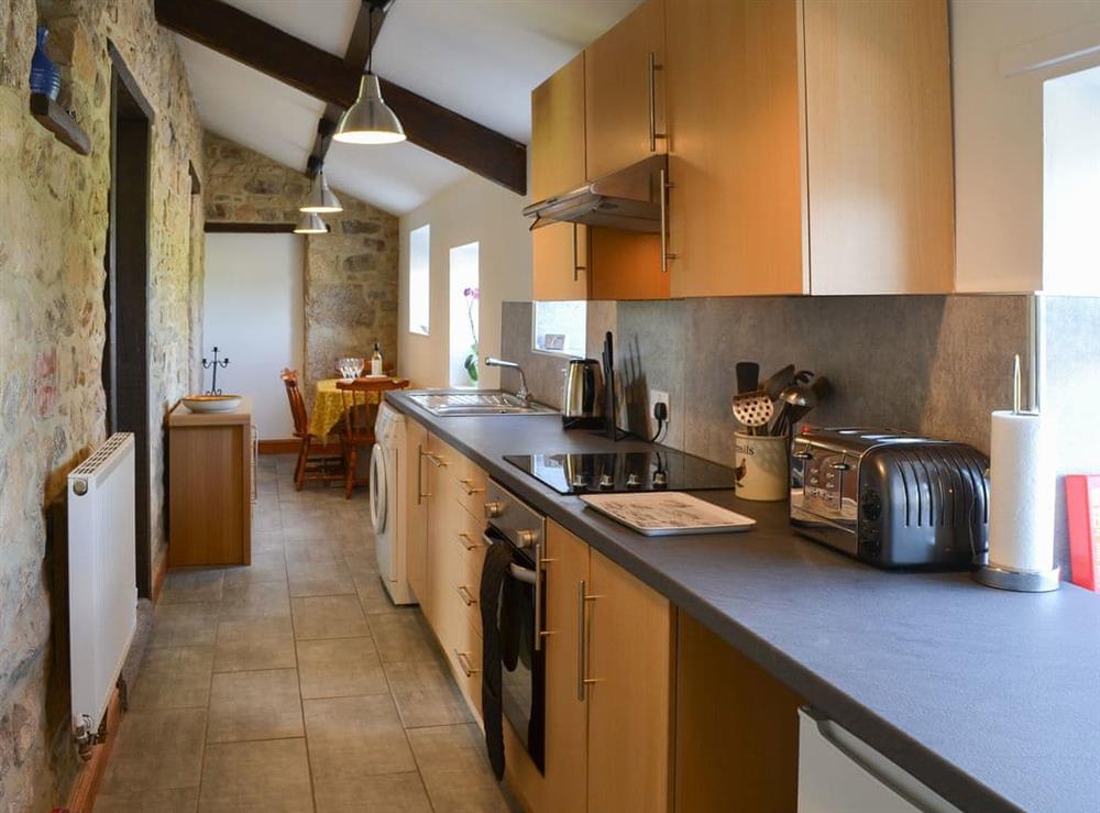 Tile-floored galley style kitchen at Mains Cottage in Belford, near Bamburgh, Northumberland