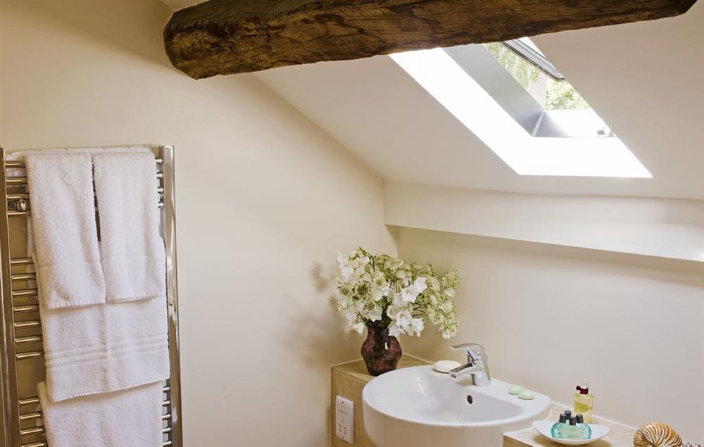 The attached shower room is quirky and original, with beams, tiling and heated towel rail at Malbanc Cottage, Whitchurch