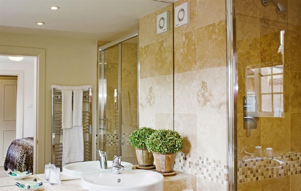 The bathroom has a large mirror and is fully tiled with heated towel rail at Malbanc Cottage, Whitchurch