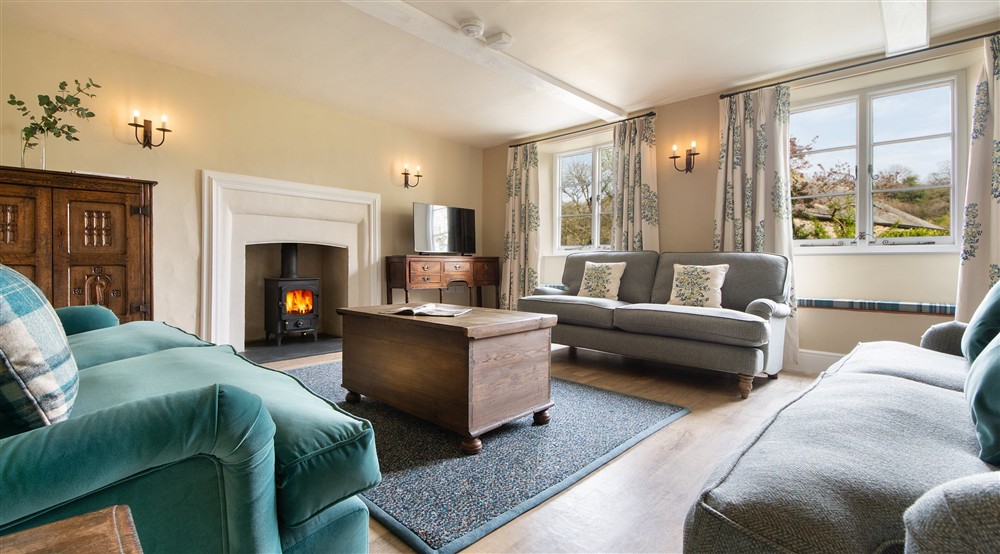 The sitting room with woodburner, sofas and television at Malt House in Saltash, Cornwall