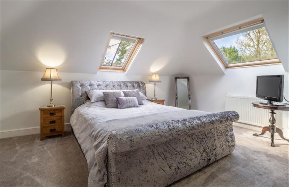 Master bedroom with 6’ super-king size bed and television at Maltings Lodge, Chelsworth
