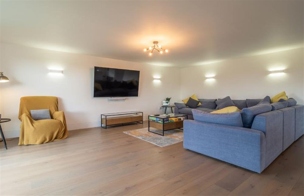 Sitting room with extra large corner sofa and wall-mounted television at Mandalore, Henham