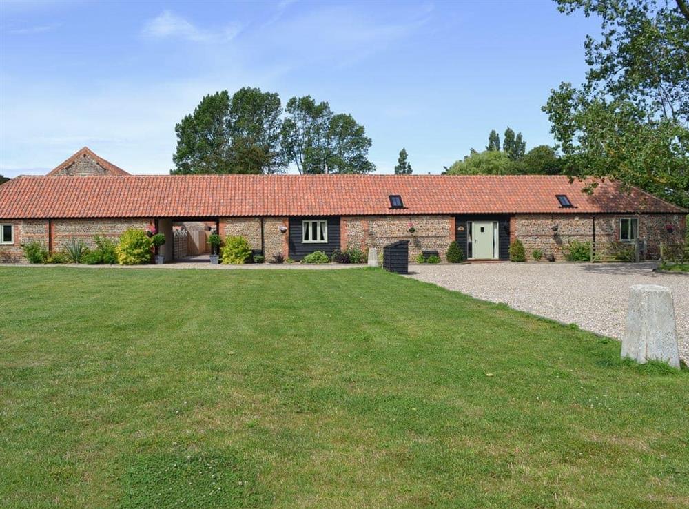 Exterior, traditional Norfolk brick and flint barns, with large lawned garden at Badgers Retreat, 