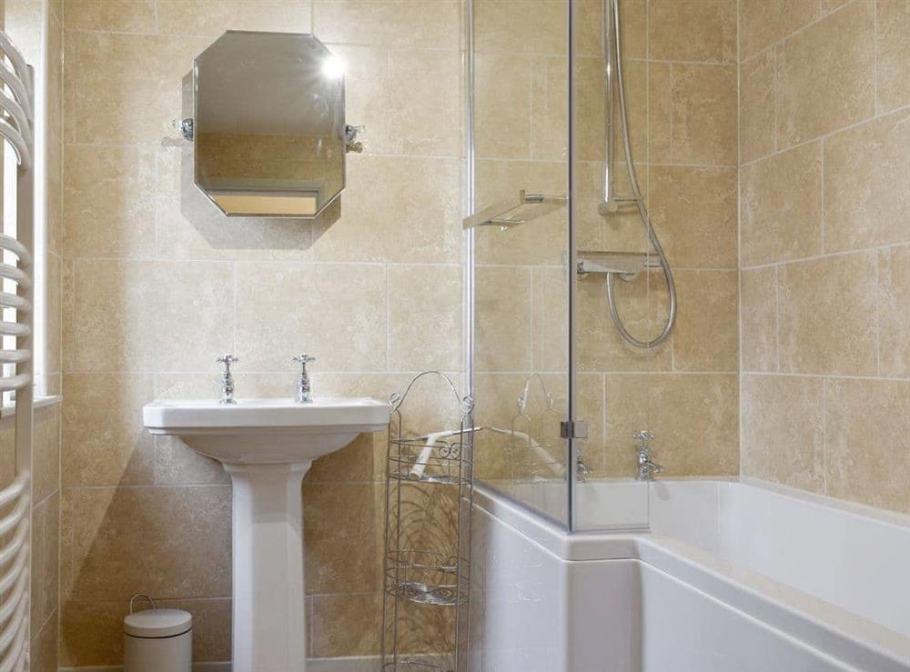 Family bathroom with shower over bath at Manor House Cottage in Holme on Swale, near Thirsk, North Yorkshire