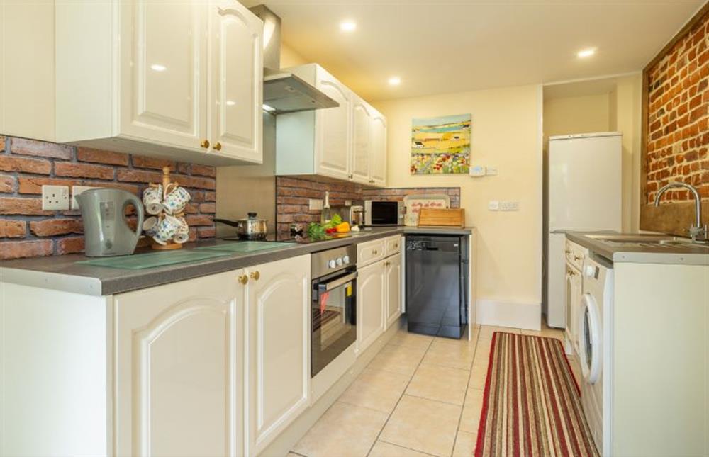 Ground floor: Well-equipped kitchen with exposed brickwork at Margarets Cottage, Potter Heigham near Great Yarmouth