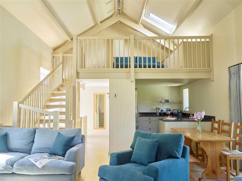 The open-plan kitchen, sitting and dining area, with a gated mezzanine area at Maristow Cottage, Dartmouth 