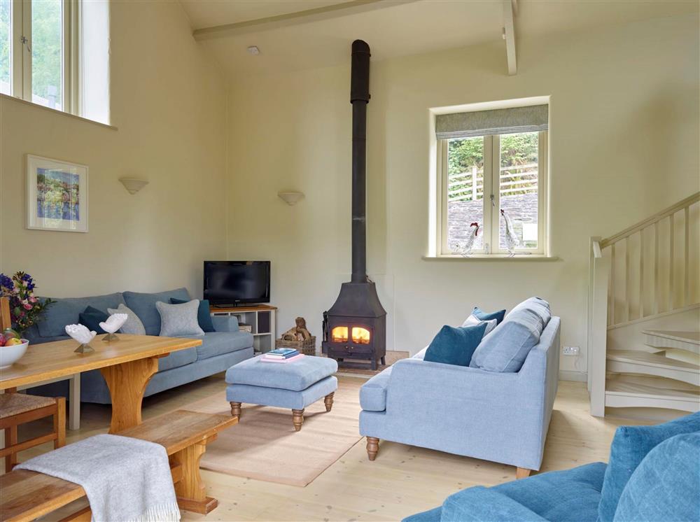 The open-plan sitting and dining area, with a wood burning stove  at Maristow Cottage, Dartmouth 