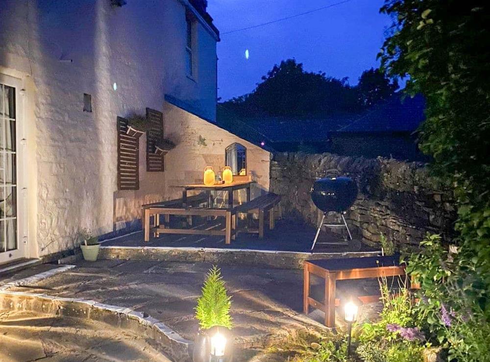 Paved patio area with outdoor furniture and BBQ at Mark Close Farmhouse in Alston, Cumbria