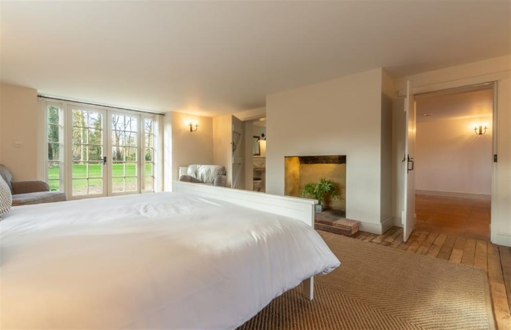 Ground floor: Master bedroom with feature fireplace at Market Square House, Fring near Kings Lynn