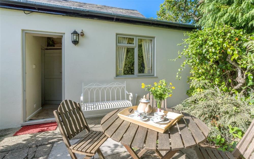 Enclosed patio garden area with table and chairs at Marquis of Lorne Cottage in Bridport