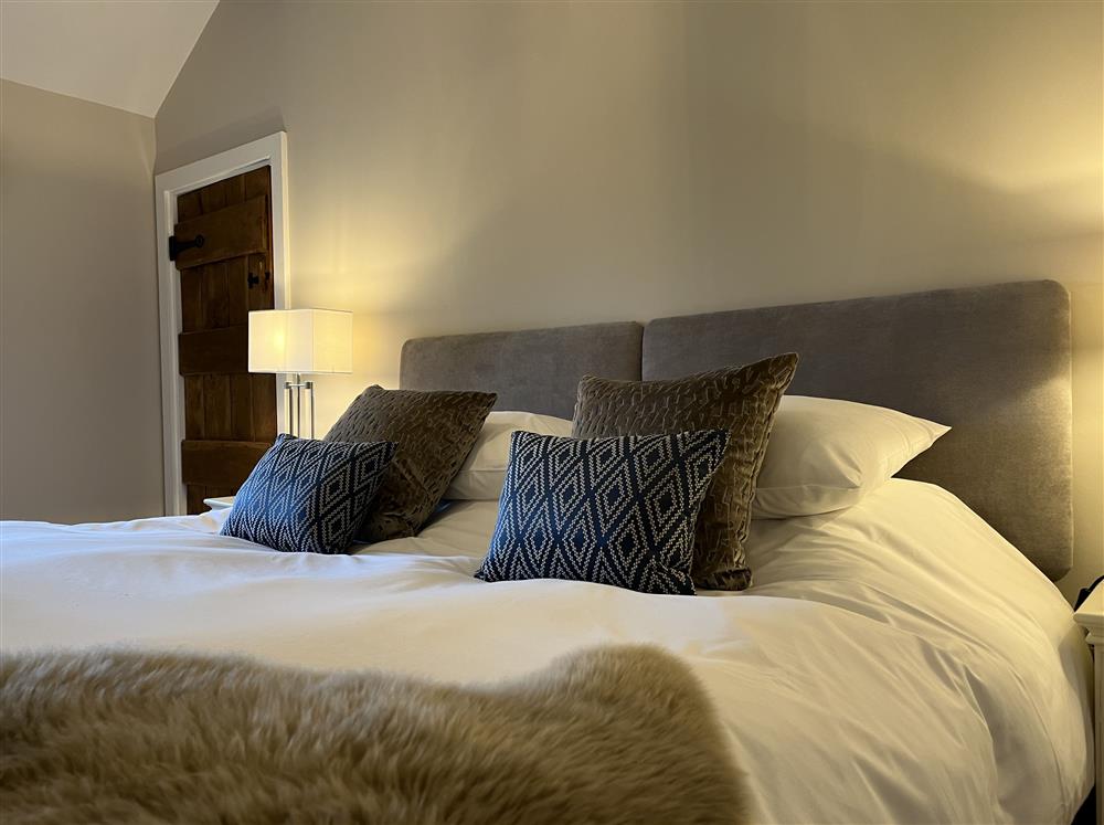 Lupin bedroom with a 6’ super-king size bed at Marrington Mill, Montgomery