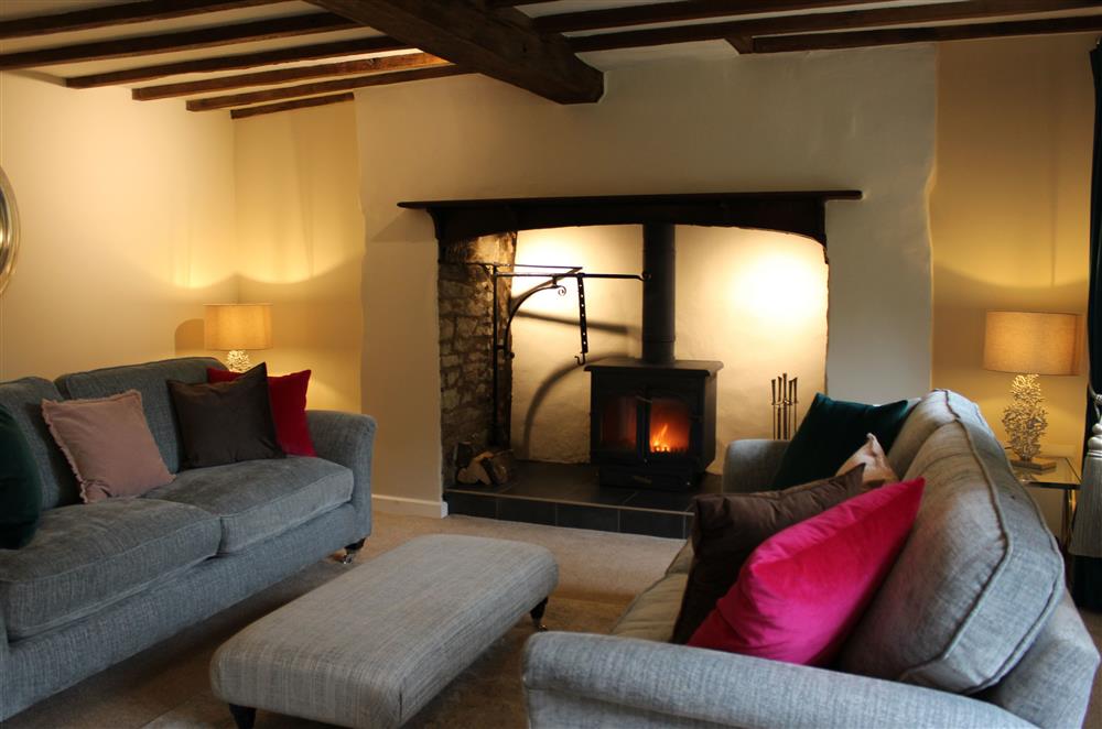 The sitting room boasts a large inglenook fireplace and electric wood burning stove at Marrington Mill, Montgomery