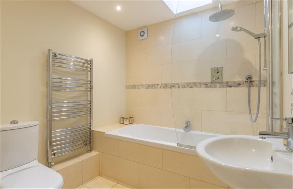 Ground floor: The bathroom has a bath with shower over at Marsh Retreat, Brancaster near Kings Lynn
