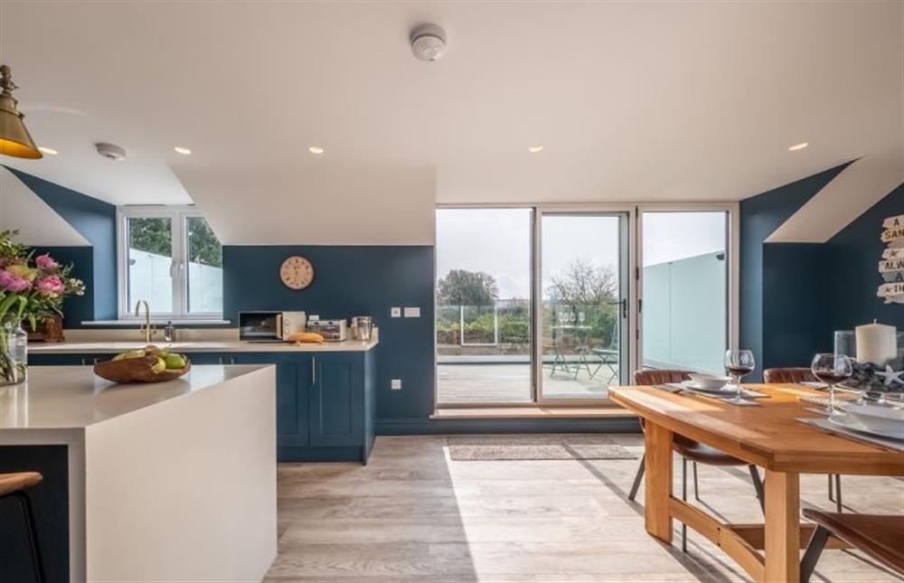 The kitchen and dining area leads out onto the spacious balcony  at May Cottage, Titchwell