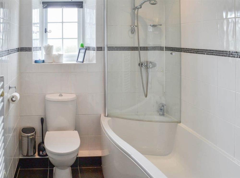 Great bathroom with shower over bath and heated towel rail at May Cottage in Tywardreath, near Fowey, Cornwall