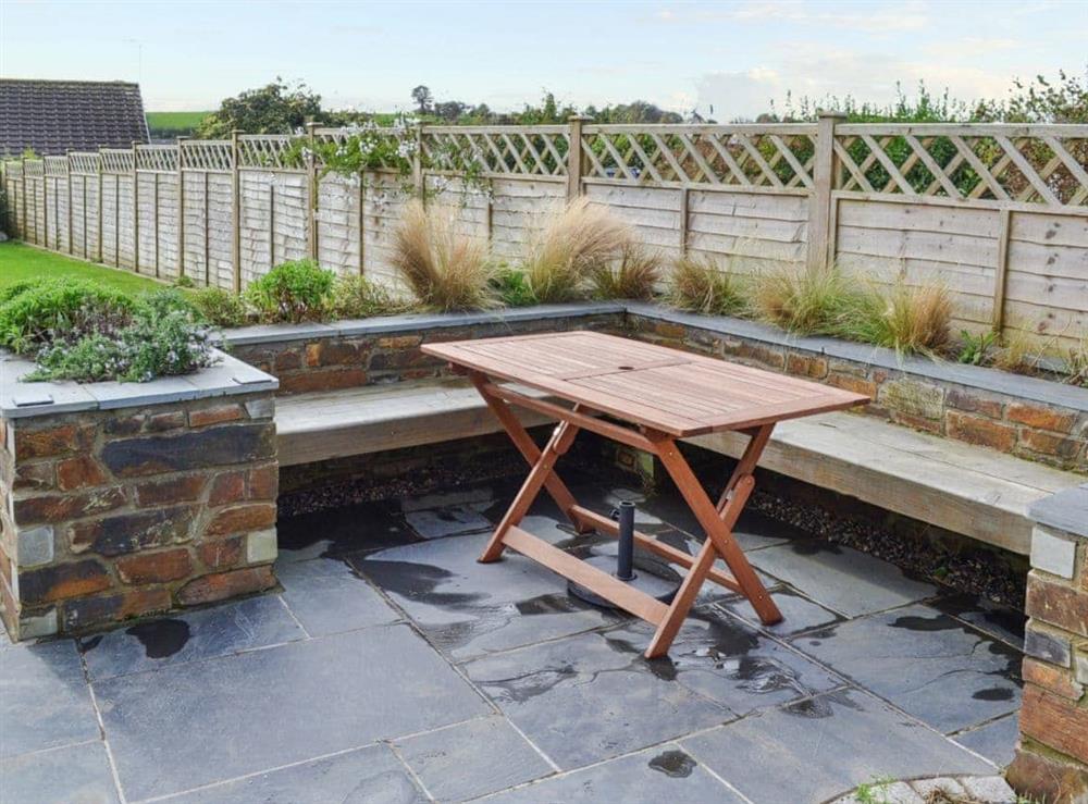 Slate-floored patio with seating and table at May Cottage in Tywardreath, near Fowey, Cornwall