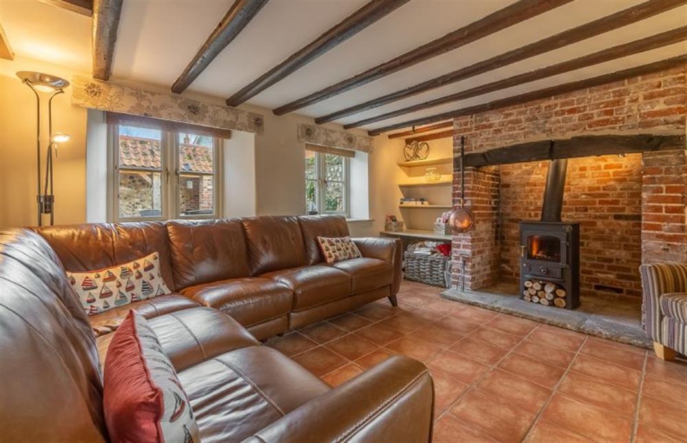 Ground floor: Sitting room has feature fireplace and wood burning stove (photo 2) at Mayes Cottage, Brancaster near Kings Lynn