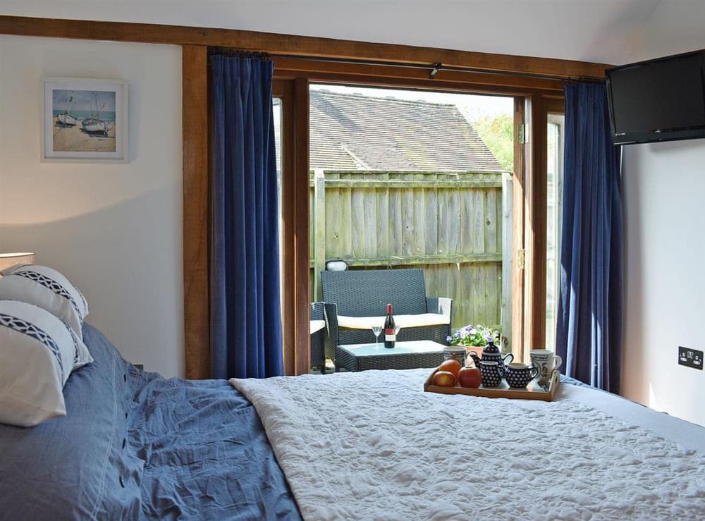 Sumptuous double bedroom French doors leading to garden (photo 2) at Meadow Barn in East Burton, near Wool, Dorset
