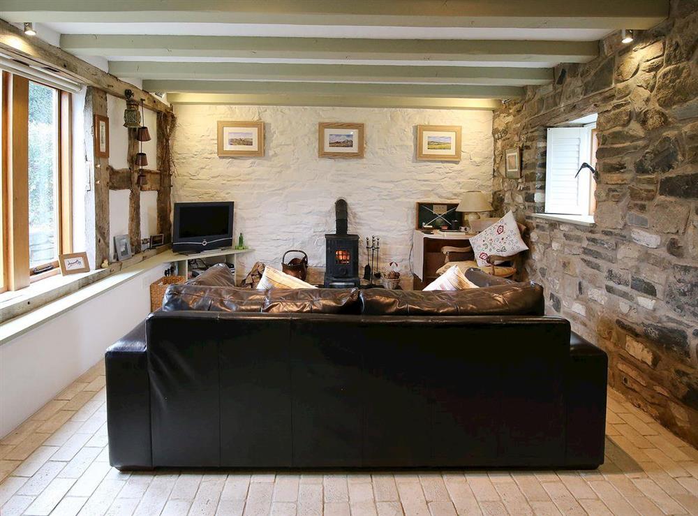 Living room with exposed stone wall & wood burner at Meadow Barn in Pennerley, Minsterley, Shropshire., Great Britain