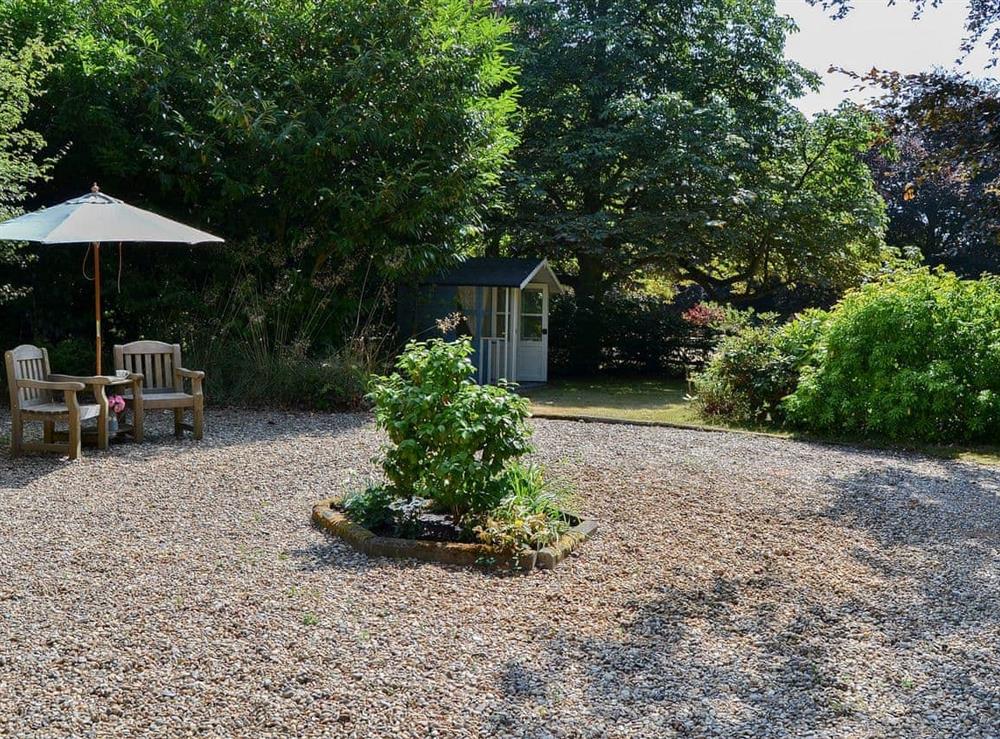 Gravelled area with seating between the house and the lawned garden at Meadow Cottage in Irstead, near Wroxham, Norfolk