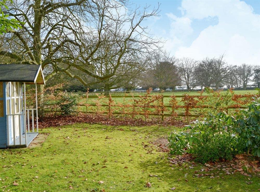 Large enclosed lawned garden with summerhouse at Meadow Cottage in Irstead, near Wroxham, Norfolk
