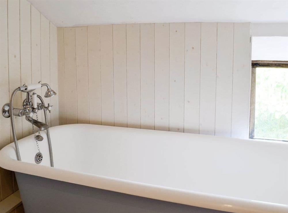 Roll-top bath with shower attachment at Meadow Cottage in Linstead Parva, near Southwold, Suffolk