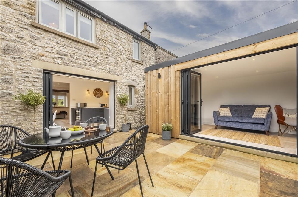 The rear garden, with space for alfresco dining and access to the garden room  at Meadow View, near Buxton