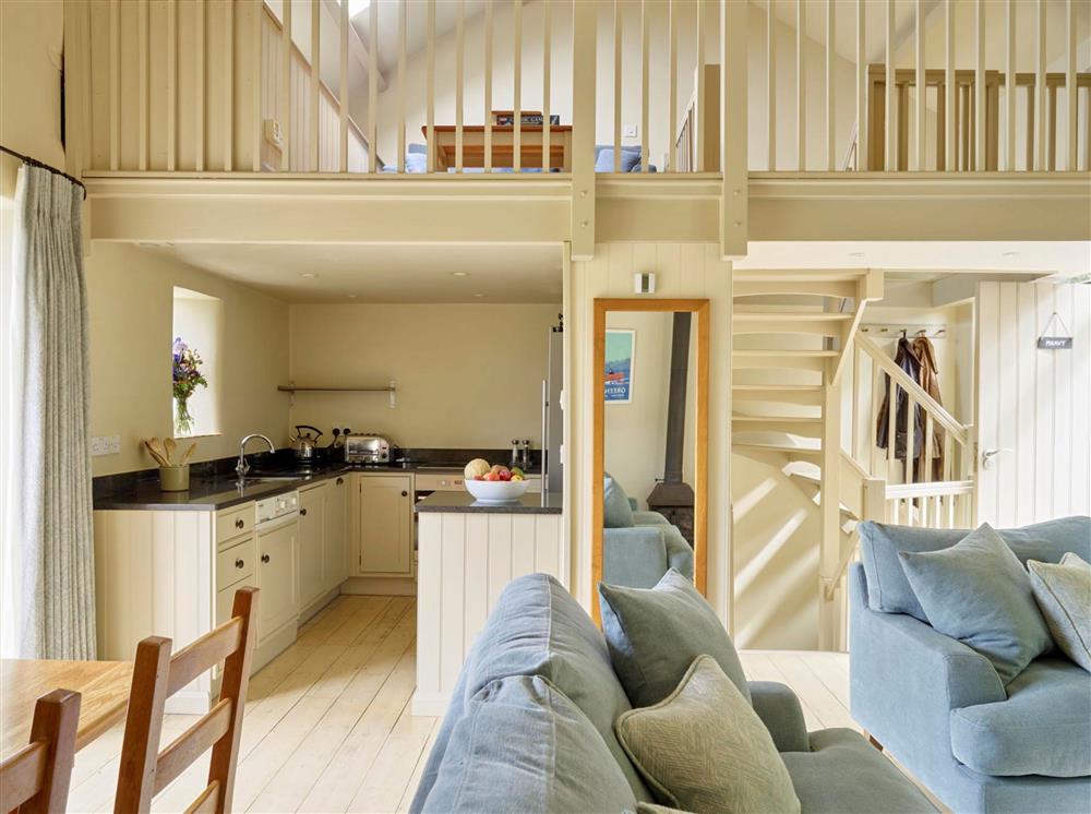 The open-plan kitchen, sitting and dining area, with a gated mezzanine area at Meavy Cottage, Dartmouth
