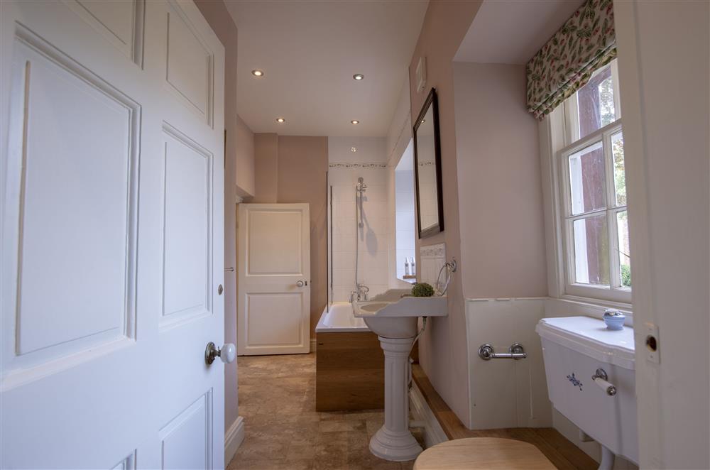 Bath with an overhead power shower in French Empire’s en-suite bathroom  at Melmerby Hall and Stag Cottage, Melmerby, near Langwathby, Penrith