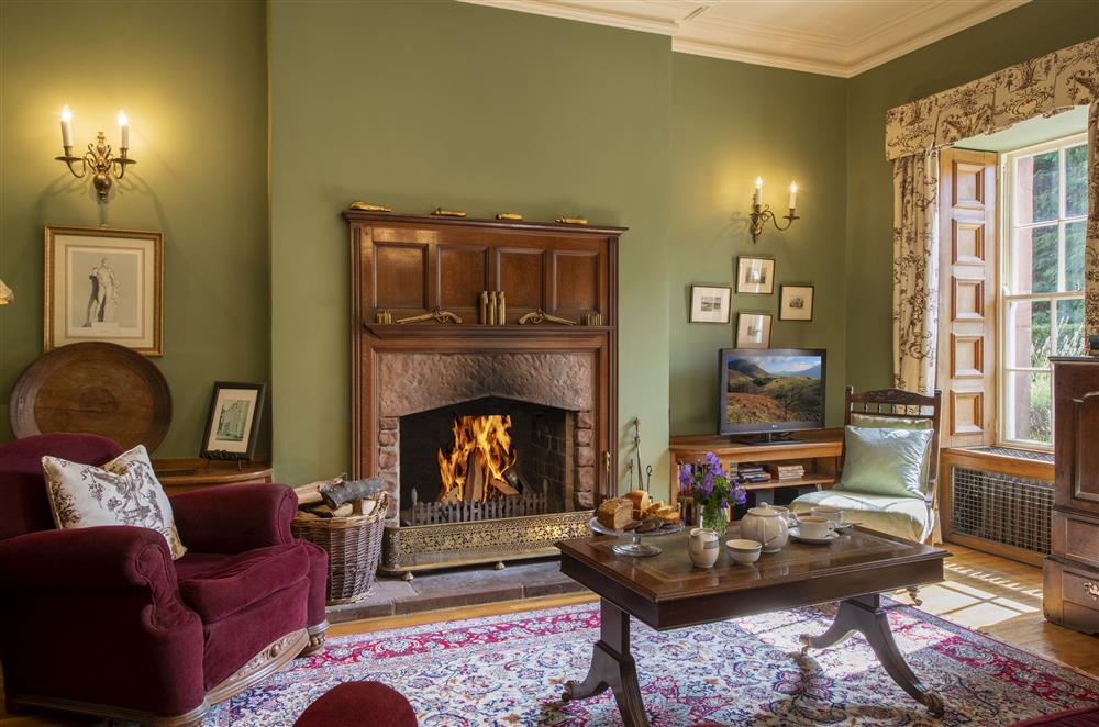 Enjoy the open fire in the library on cooler evenings at Melmerby Hall and Stag Cottage, Melmerby, near Langwathby, Penrith