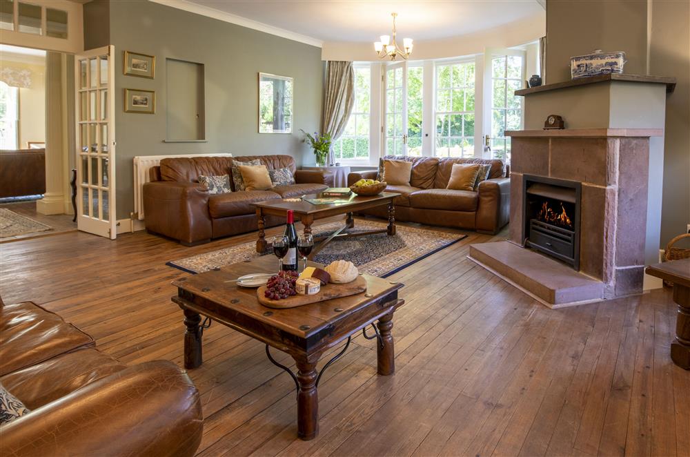 Spacious sitting room with sumptuous seating and open gas fire at Melmerby Hall and Stag Cottage, Melmerby, near Langwathby, Penrith