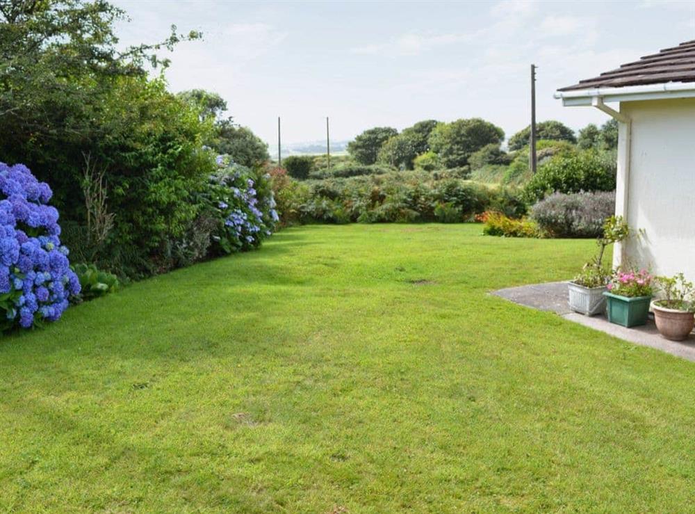 Large enclosed lawned garden with patio and garden furniture at Merriview in Balwest, near Marazion, Cornwall