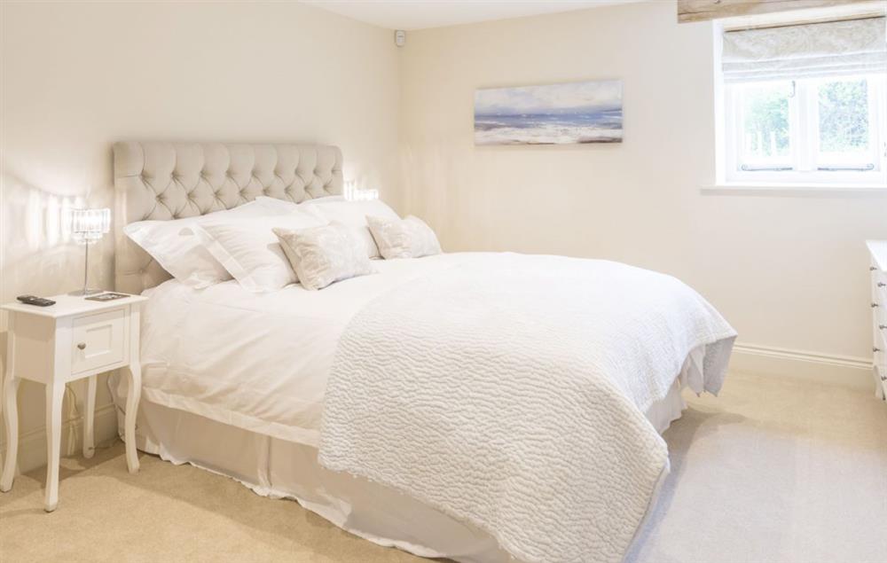 Bedroom one with king-size bed and en-suite bathroom at Merry Hill Barn, Portesham