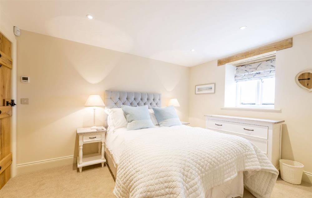 Bedroom two with double bed and en-suite shower room at Merry Hill Barn, Portesham