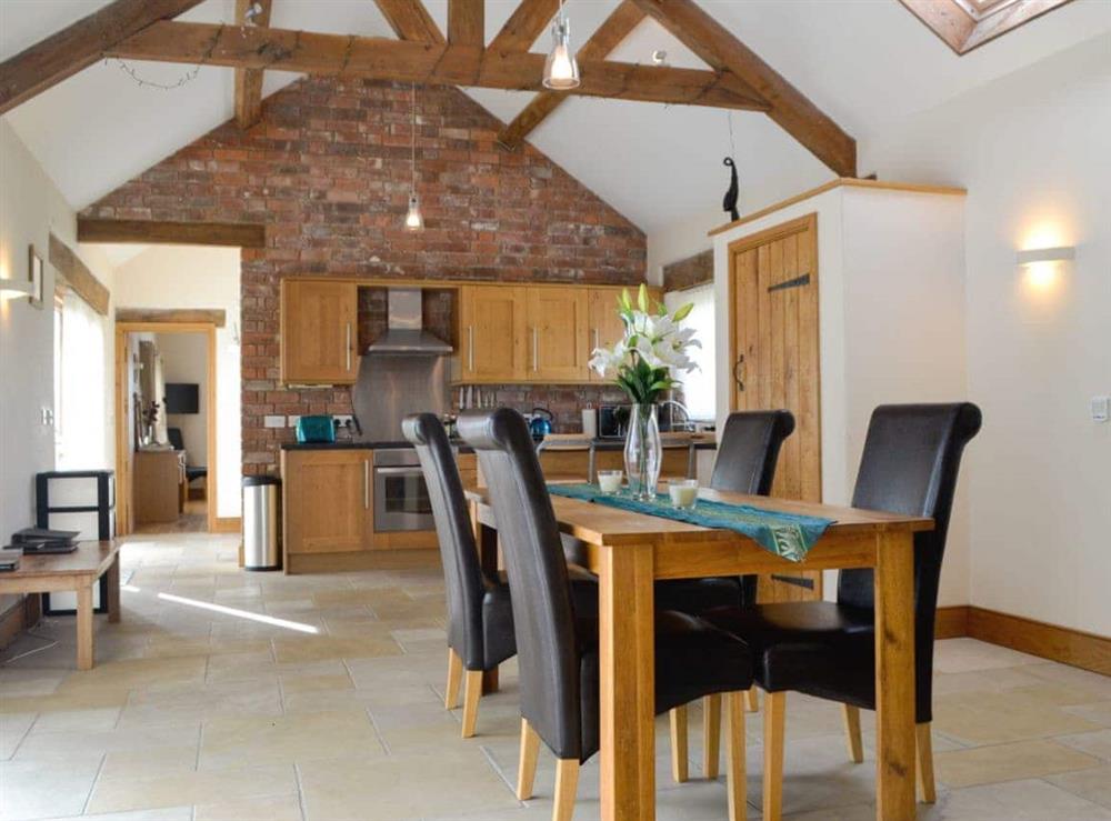 Open plan living/ kitchen/ dining room with original features such as traditional oak trusses at Blackberry Barn, 