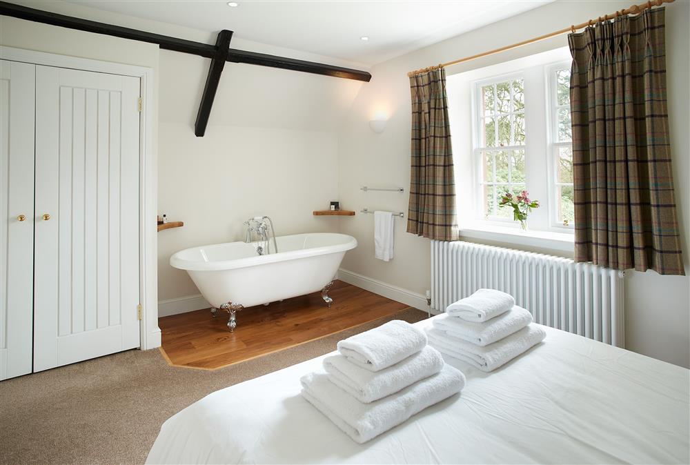 Bedroom with a 5’ king-size bed and decadent roll top bath at Middle Lodge, Netherby Hall, Longtown