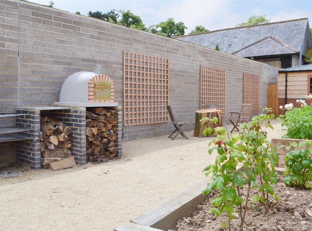 Shared outdoor pizza oven and BBQ area at Chiddock Cottage, 