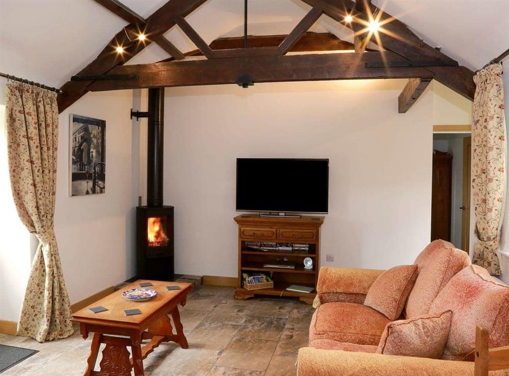 Comfortable living/dining room with wood burner at The Cottage, 