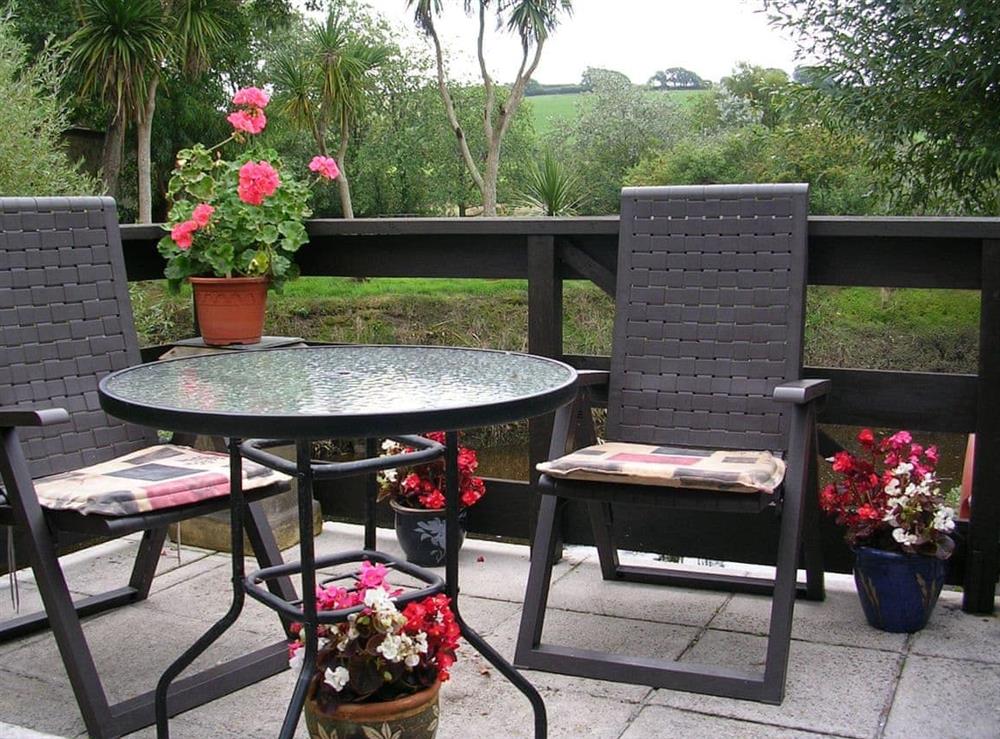 Patio area with outdoor furniture at Mill Cottage in Aveton Gifford, near Kingsbridge, Devon