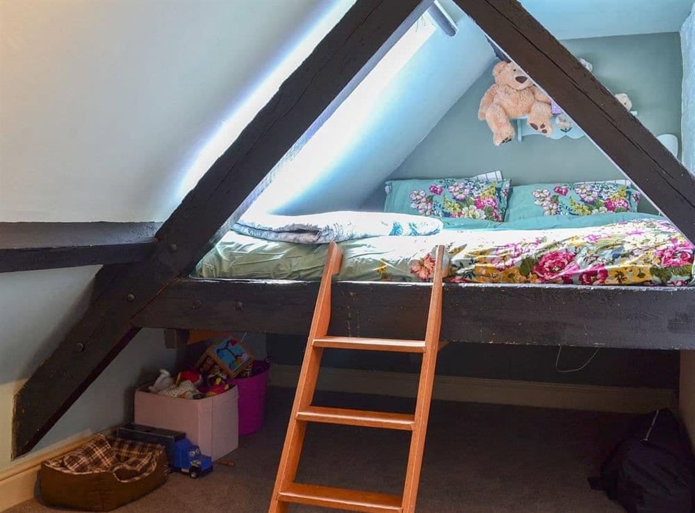 Loft with beams and a kingsize bed at Mill Cottage in Bielby, near York, North Yorkshire