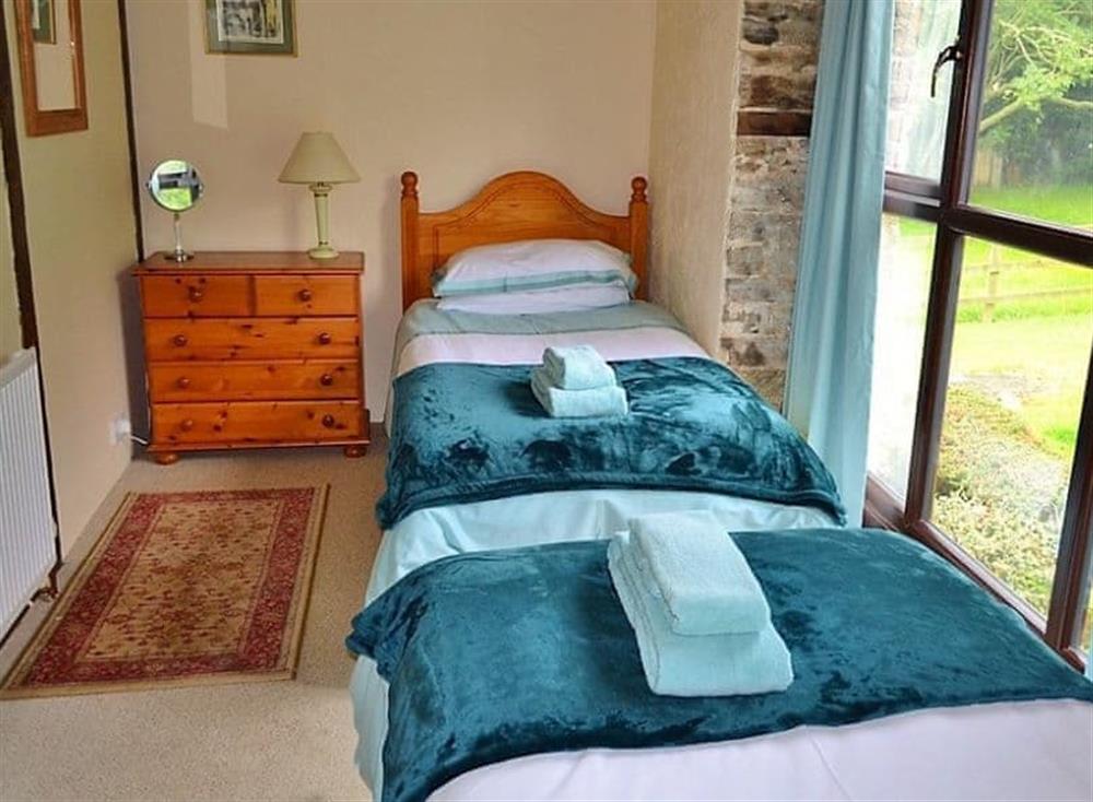 The twin bedroom has large floor to ceiling windows looking out across the garden (photo 2) at Mill Cottage in Fowey, Cornwall
