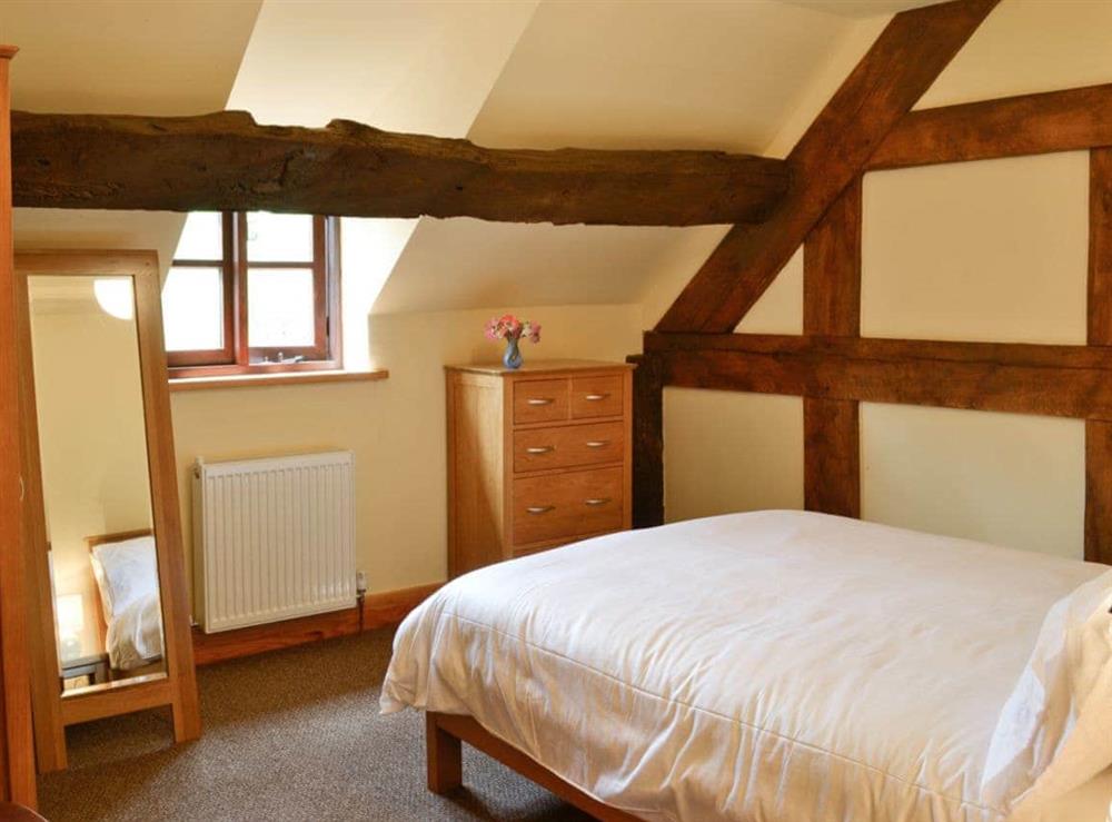Double bedroom with exposed wooden beams at Mill Cottage in Peterchurch, near Hay-on-Wye, Herefordshire