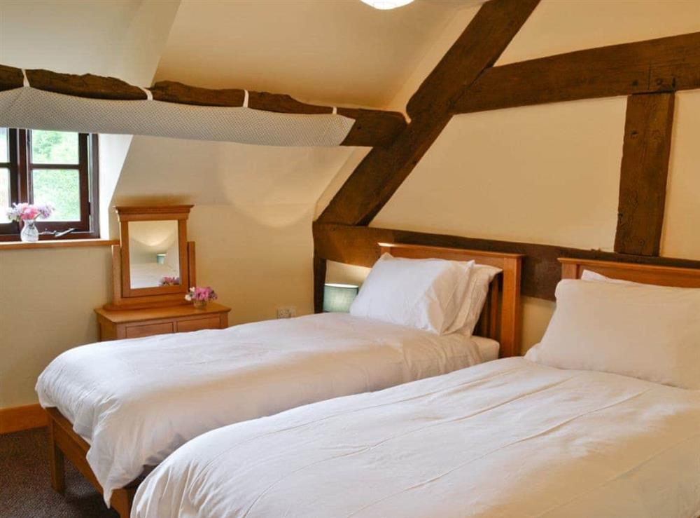 Twin bedroom with exposed wooden beams at Mill Cottage in Peterchurch, near Hay-on-Wye, Herefordshire