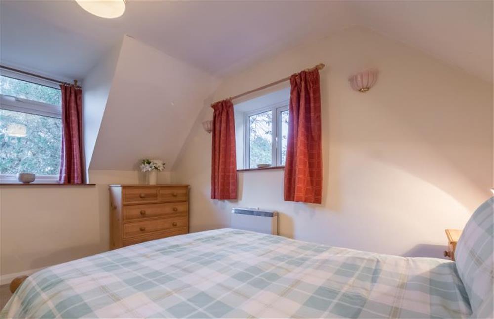 First floor: The duel aspect Master bedroom has a double bed at Mill House Cottage, Brancaster near Kings Lynn