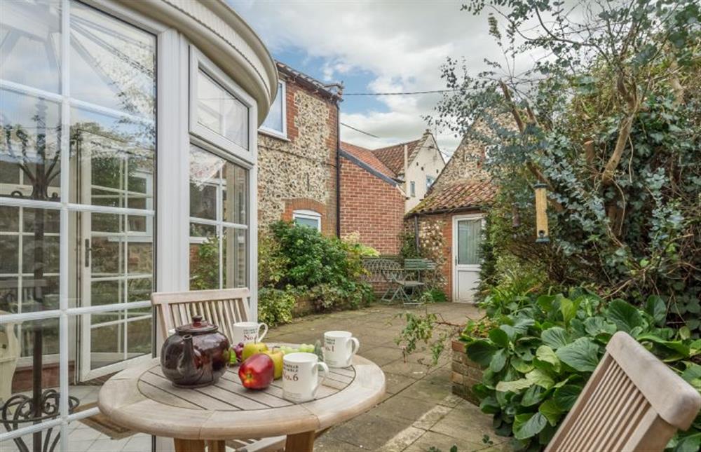 The pretty courtyard is a pleasant place to sit at Mill House Cottage, Brancaster near Kings Lynn